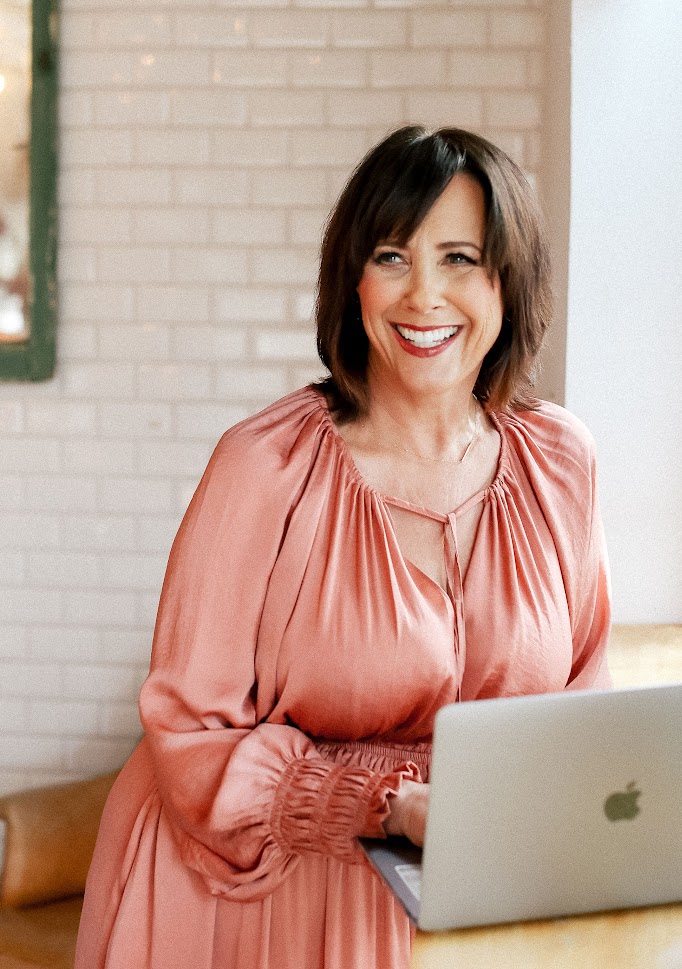 Christina L. Woods smiling at her laptop